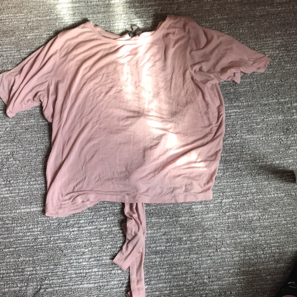 A light pink t-shirt with a tie on the back